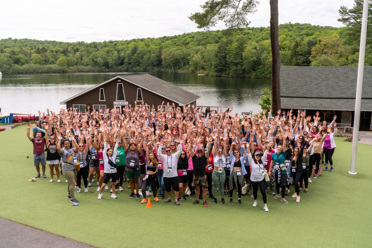 A large group of people smiling during their offsite retreat