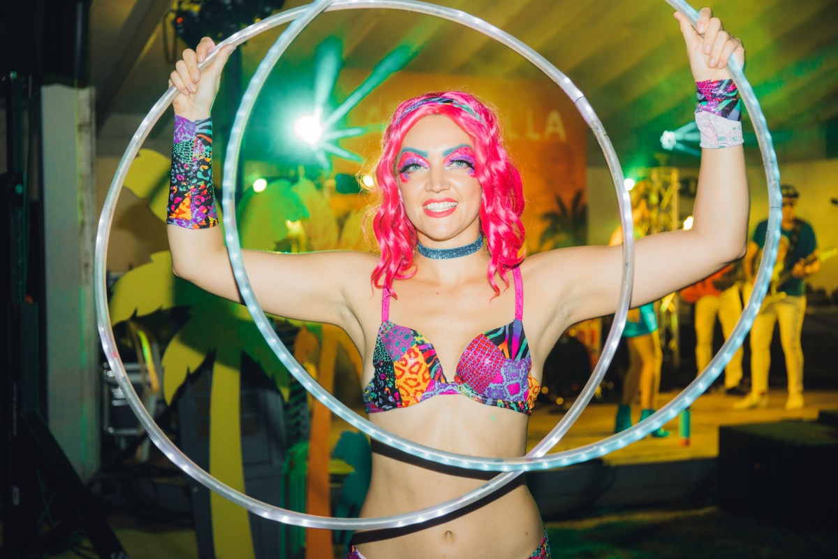 Unique Event Themes: A girl parties at a Coachella themed event while a band plays in the background.