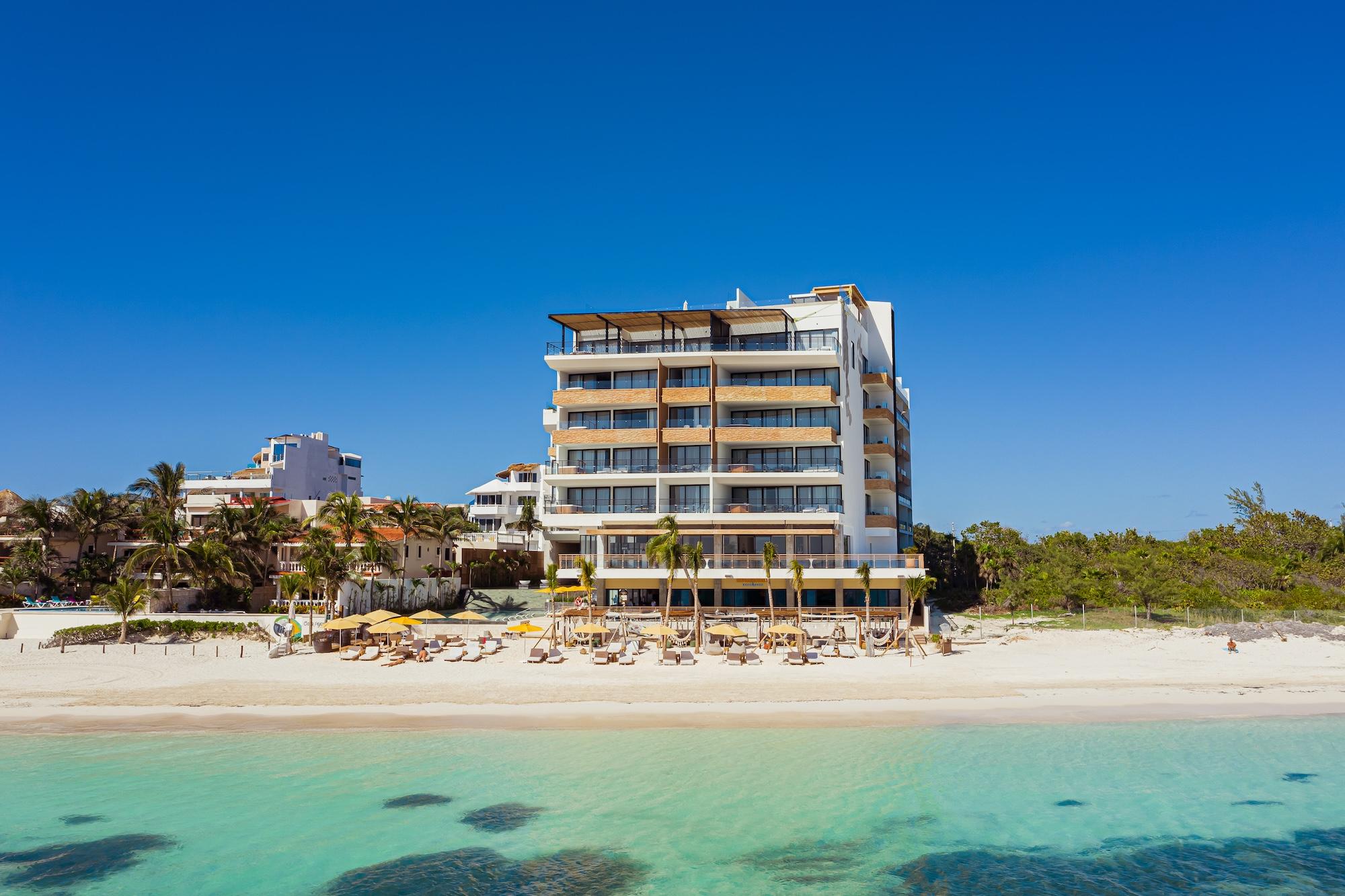 An aerial photo of The Fives Oceanfront Hotel in Mexico, you can see the blue waters, sandy white beach and the front of the hotel